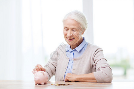 储蓄,金钱,金保险,退休人们的微笑的老年女子家里把硬币放进储蓄罐图片