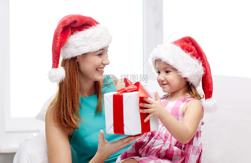 诞节,假期,家庭,童人的快乐的母亲小女孩戴着诞帽,家里礼品盒图片