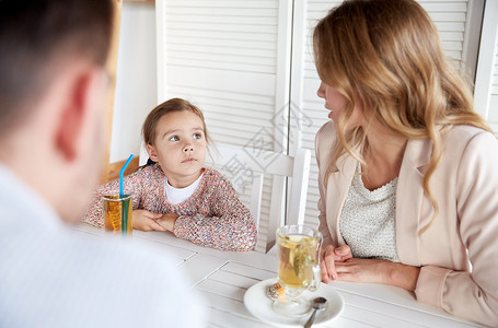 家庭父母沟通人的快乐的母亲父亲小女孩餐馆咖啡馆吃饭交谈图片
