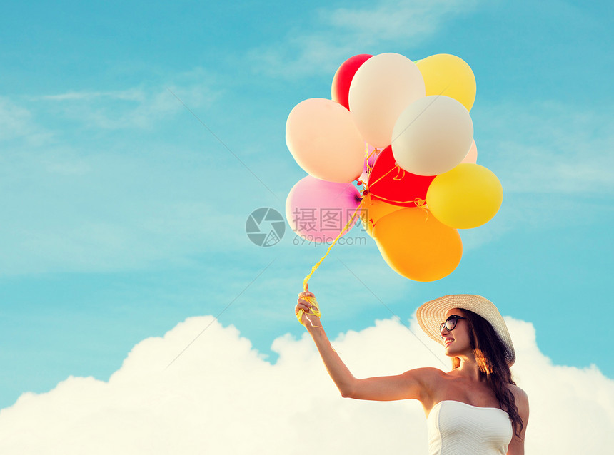 快乐,夏天,假期人们的微笑的轻女人戴着太阳镜,蓝天云的背景上戴着气球图片