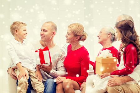 家庭,假期,代,诞节人们的微笑的家庭与礼品盒坐沙发上,家里交谈图片