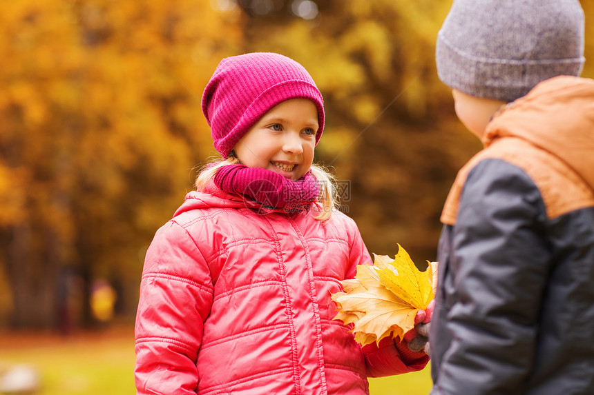 童,休闲,友谊人的快乐的小男孩给女孩枫叶秋天的公园图片