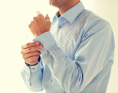 人,商业,时尚服装的男人紧固按钮衬衫袖子家里图片