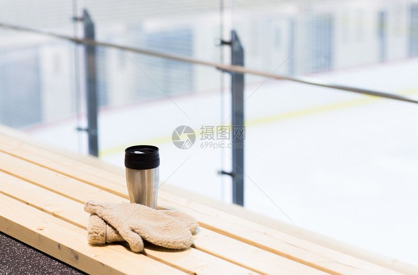 热饮,冬季休闲热水瓶杯羊皮手套长凳上的冰场竞技场图片