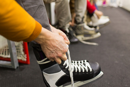 人们,冬季运动休闲亲密的朋友穿着系鞋带滑冰场图片