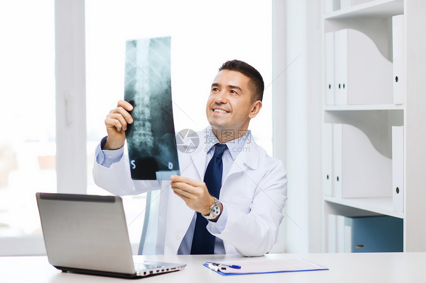 医疗保健,技术,伦琴,人医学微笑的男医生穿着白色外套,带着笔记本电脑医疗办公室看X光图片