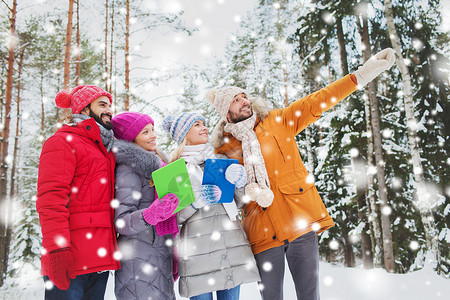 技术,季节,友谊人的群微笑的男人女人与平板电脑手指冬季森林图片