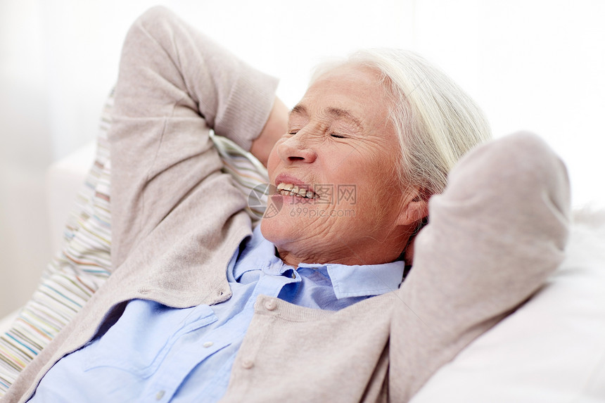 龄,放松人的快乐的微笑老妇女躺沙发上,家梦图片