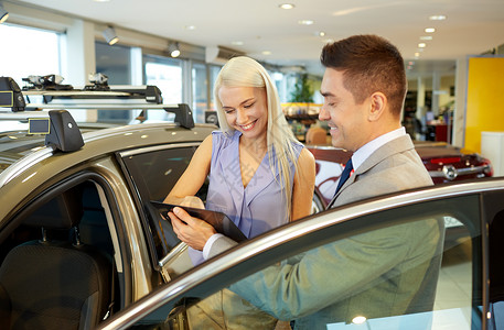 汽车业务,汽车销售,消费主义人的快乐的女人与汽车经销商车展沙龙图片