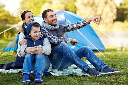 露营,旅游,徒步旅行人们的快乐的家庭帐篷营地场景指指点点图片