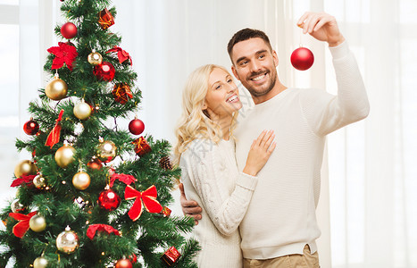 家庭,诞节,寒假人们的幸福的夫妇家里用球装饰诞树图片