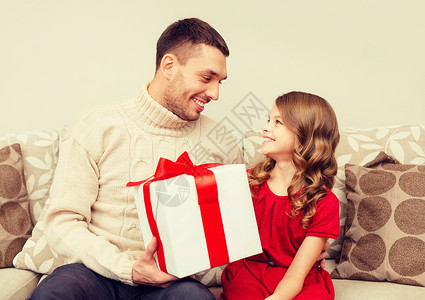 家庭,诞节,冬天,幸福人的微笑的父亲女儿抱着礼品盒,互相看着图片