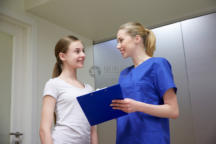 医学,保健人的微笑的女医生护士与剪贴板轻女孩医院开会图片