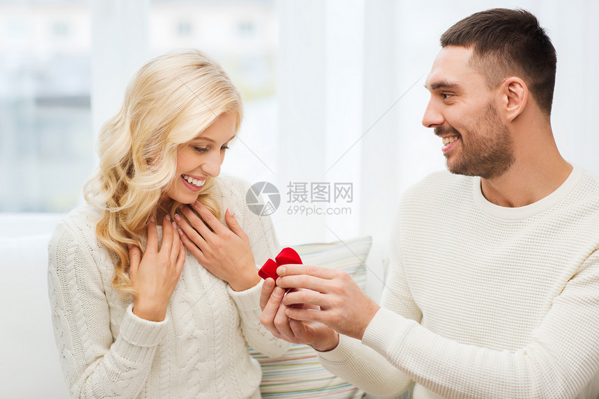 爱情,夫妻,关系,求婚假期的快乐的男人小红礼品盒里给家里的女人送订婚戒指图片