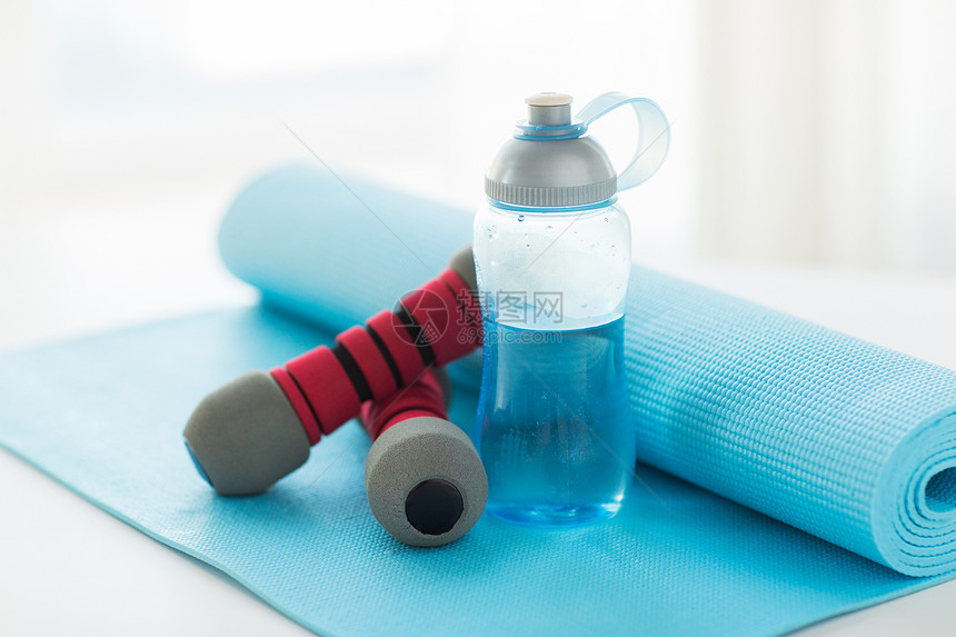 运动,健身,健康的生活方式物品的瓶与水,哑铃运动垫图片