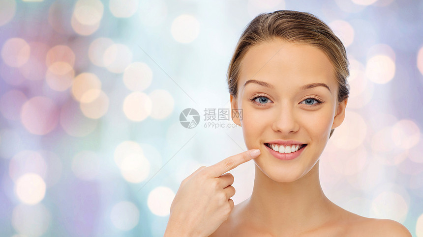 美丽,人,牙科护理卫生快乐的轻女人指着她的微笑牙齿紫色的节日灯光背景图片
