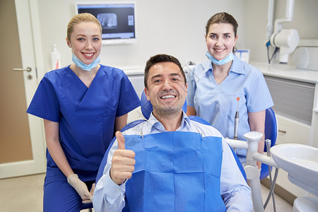 人,医学,口腔科,手势保健快乐的女牙医与助理男病人大拇指牙科诊所办公室图片