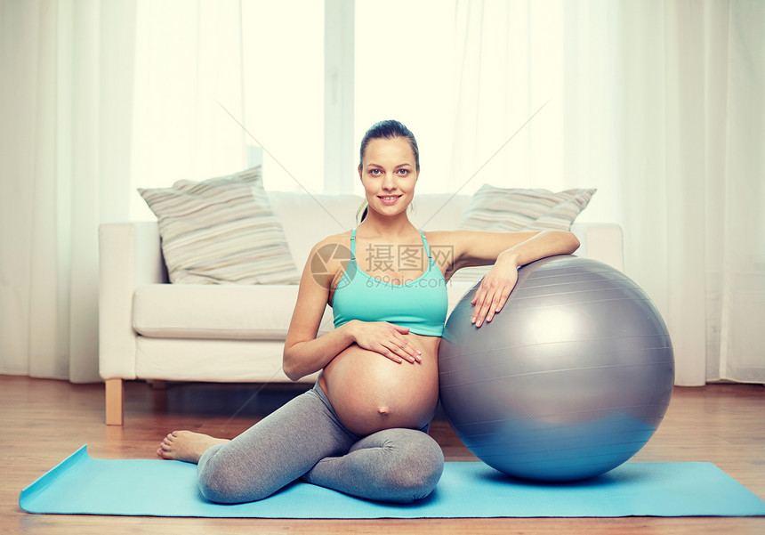 怀孕,运动,健身,人健康的生活方式快乐的孕妇家里用健身球锻炼图片