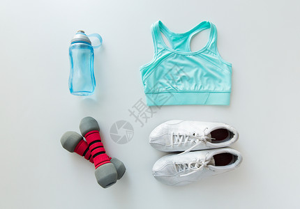 运动,健身,健康的生活方式物品的女运动服装,哑铃瓶子图片