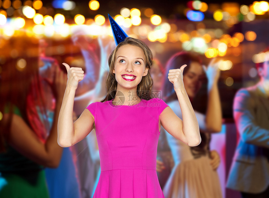 人们,节日庆祝快乐的轻妇女少女穿着粉红色的衣服派帽,人群灯光背景的夜总会聚会上竖大拇指图片
