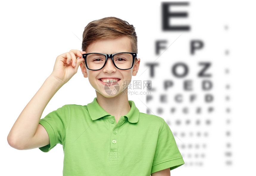 童,视力,视力人的快乐的微笑男孩绿色马球T恤眼镜上的眼睛图表背景图片