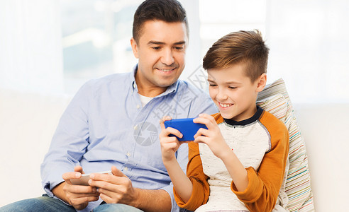 休闲,技术,家庭人的快乐的父子与智能手机短信家玩游戏图片