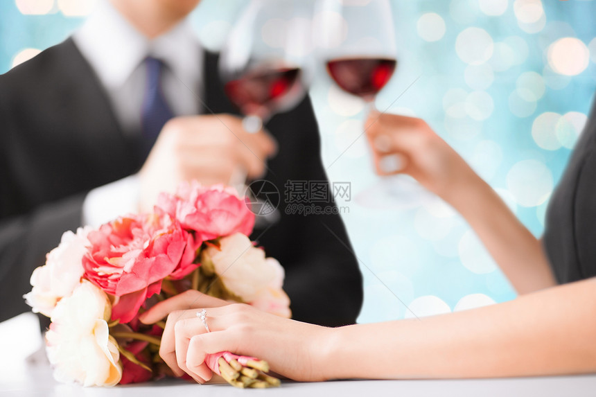 人,假日,婚姻庆祝幸福的订婚夫妇与花碰撞酒杯蓝光背景图片