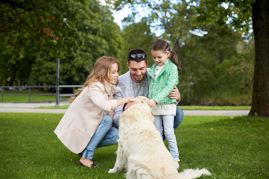 家庭,宠物,家畜人的快乐的家庭与拉布拉多猎犬公园散步图片