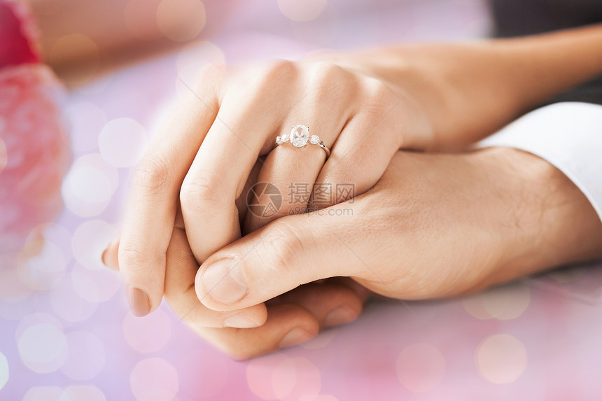 人,假期,订婚爱的亲密的夫妇牵手钻石戒指假日灯光背景图片