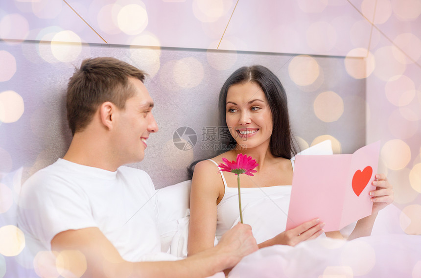 关系,假期,情人节爱情微笑的夫妇床上与明信片粉红色的花灯光背景图片