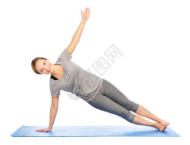 健身,运动,人健康的生活方式妇女瑜伽侧板姿势垫子上背景图片