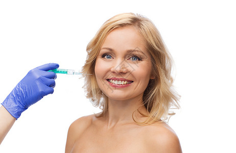 逆龄抗衰美容,抗衰容手术的微笑的女人脸美容师携手手套与注射器注射脸颊背景