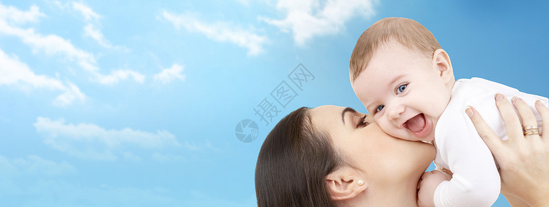 家庭,母亲,孩子,父母人的快乐的母亲亲吻她的孩子蓝天云彩的背景图片