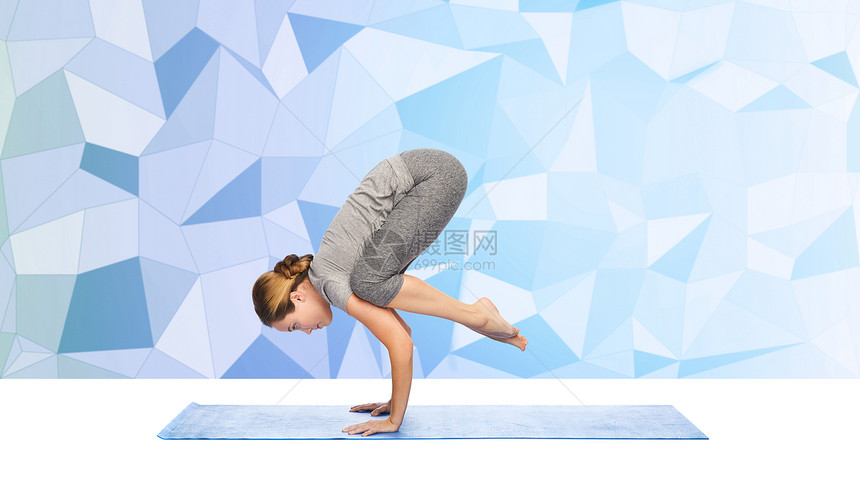 健身,运动,人健康的生活方式妇女瑜伽重机姿态垫子上的蓝色多边形背景图片