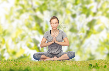 健身,运动,人健康的生活方式妇女绿色自然背景下的垫子上莲花姿势的瑜伽冥想图片