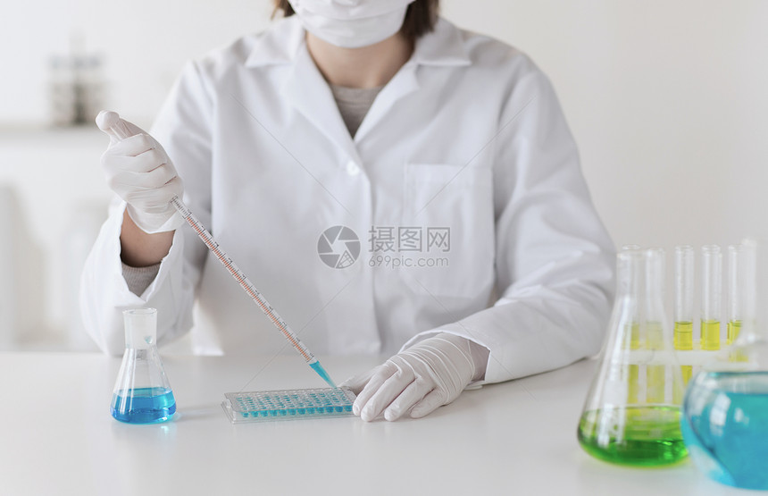 科学化学生物学医学人的用移液管烧瓶制作试验临床实验室研究的轻女科学家的特写图片