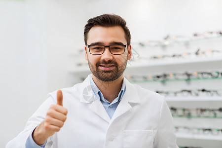 医疗保健,人,视力视觉微笑的眼镜白色外套,拇指手势光学商店图片