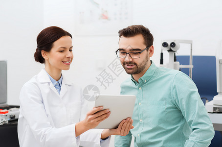 医疗保健,医学,人,视力技术女光学师与平板电脑男子眼镜眼科诊所光学商店图片