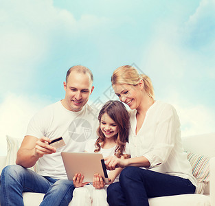家庭,购物,技术人微笑的母亲,父亲小女孩与平板电脑信用卡蓝天背景图片