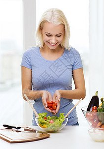 健康饮食,素食,节食人们的观念微笑的轻女人家烹饪蔬菜沙拉图片