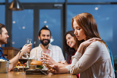 休闲,技术,网络成瘾,生活方式人的女人与智能手机朋友餐厅图片