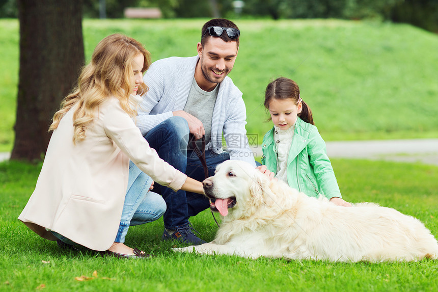 家庭,宠物,家畜人的快乐的家庭与拉布拉多猎犬夏季公园散步图片