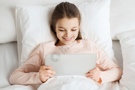 人,孩子,休息技术快乐的微笑女孩躺床上,平板电脑电脑电脑家里图片