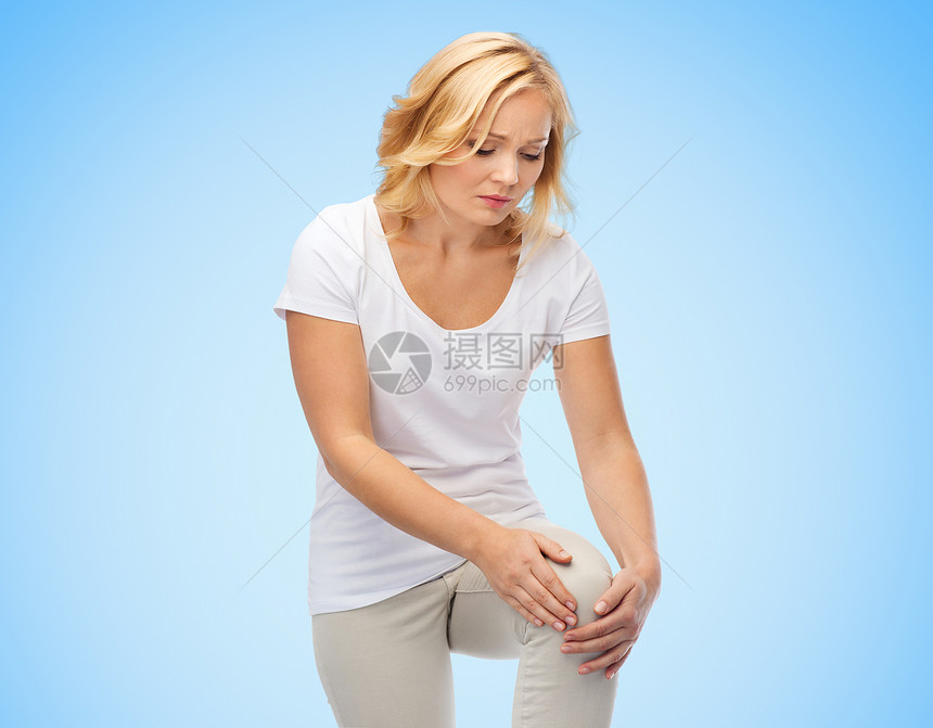 人,医疗保健问题幸的女人蓝色背景下遭受腿部疼痛图片