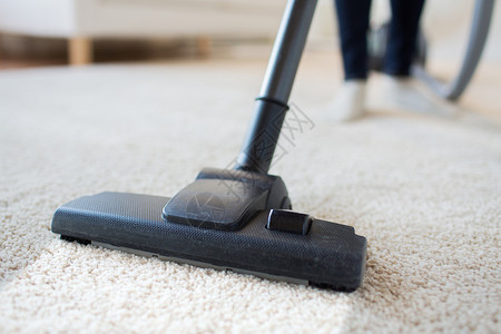 人,家务家务妇女与腿吸尘器清洁地毯家里背景图片