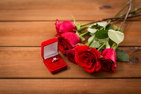 爱情,求婚,情人节假期的礼品盒与钻石订婚戒指红色玫瑰木材上图片