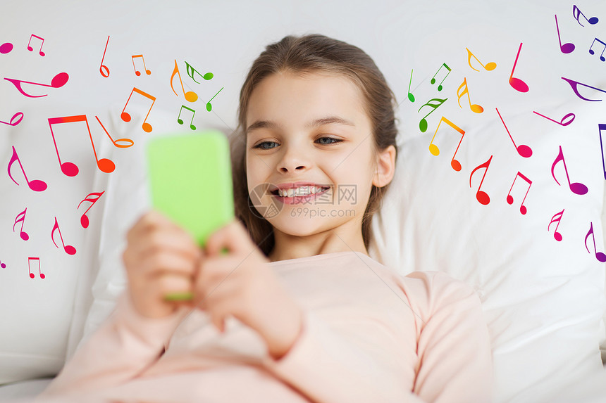 人,孩子,音乐技术快乐的微笑女孩躺家里的智能手机床上,音符图片
