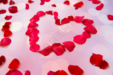 爱情,浪漫,情人节假期的红色玫瑰花瓣的心形粉红色背景图片