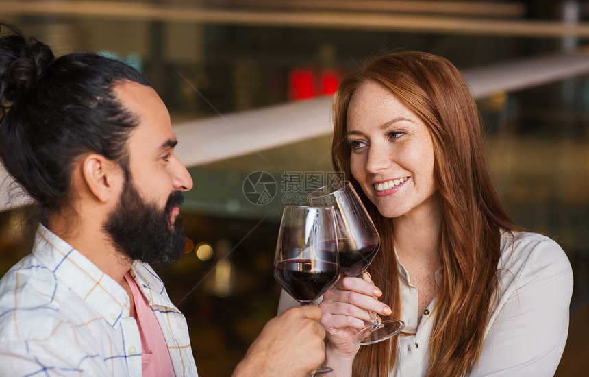 休闲,饮食,食物饮料,人假日的微笑的夫妇庆祝周纪念餐厅碰红酒杯图片