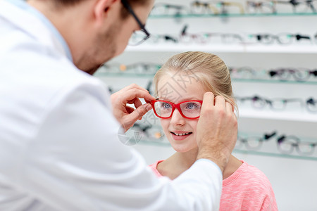 保健,人,视力视力眼镜师光学商店给小女孩的眼睛戴上眼镜图片